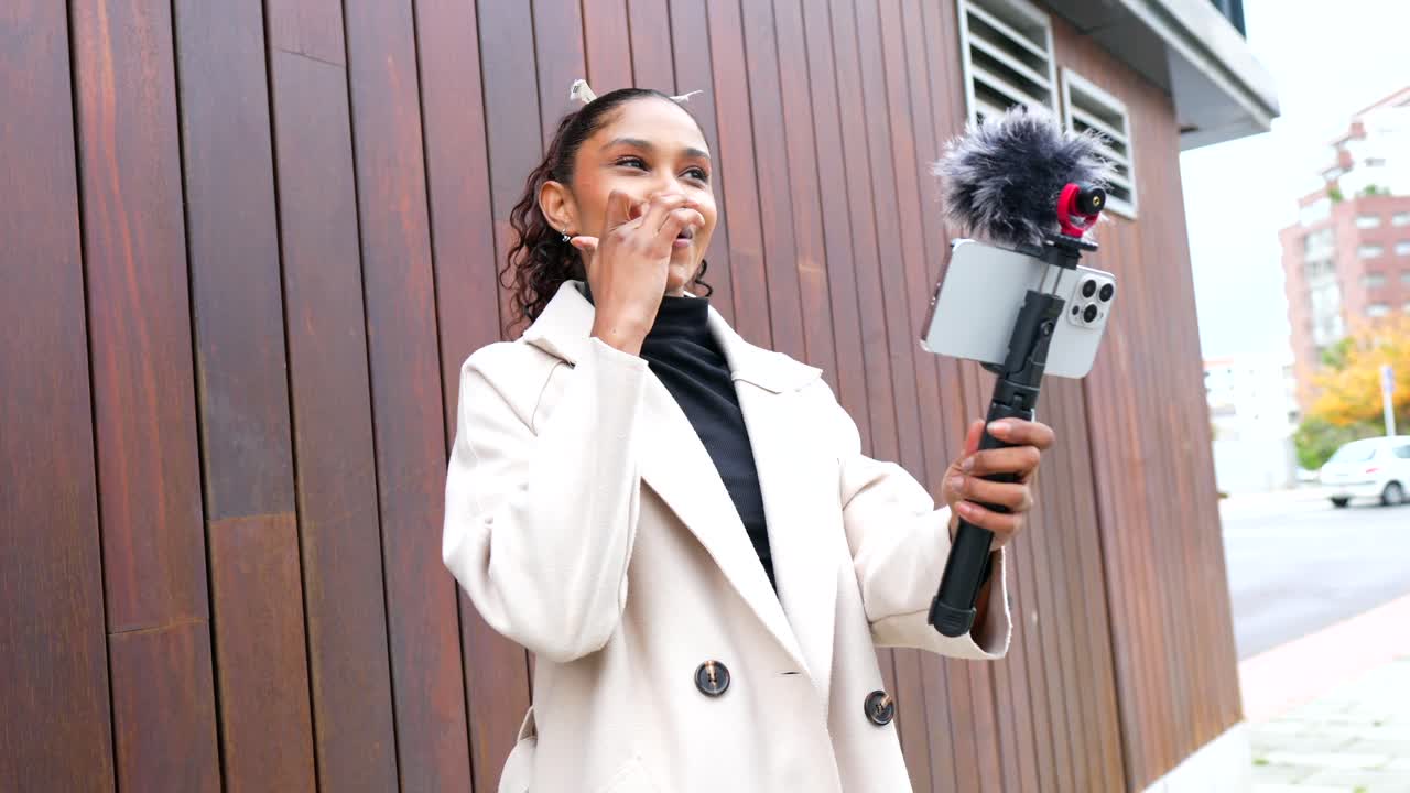 Young Brunette Woman Vlogging Outdoors with Phone and Microphone