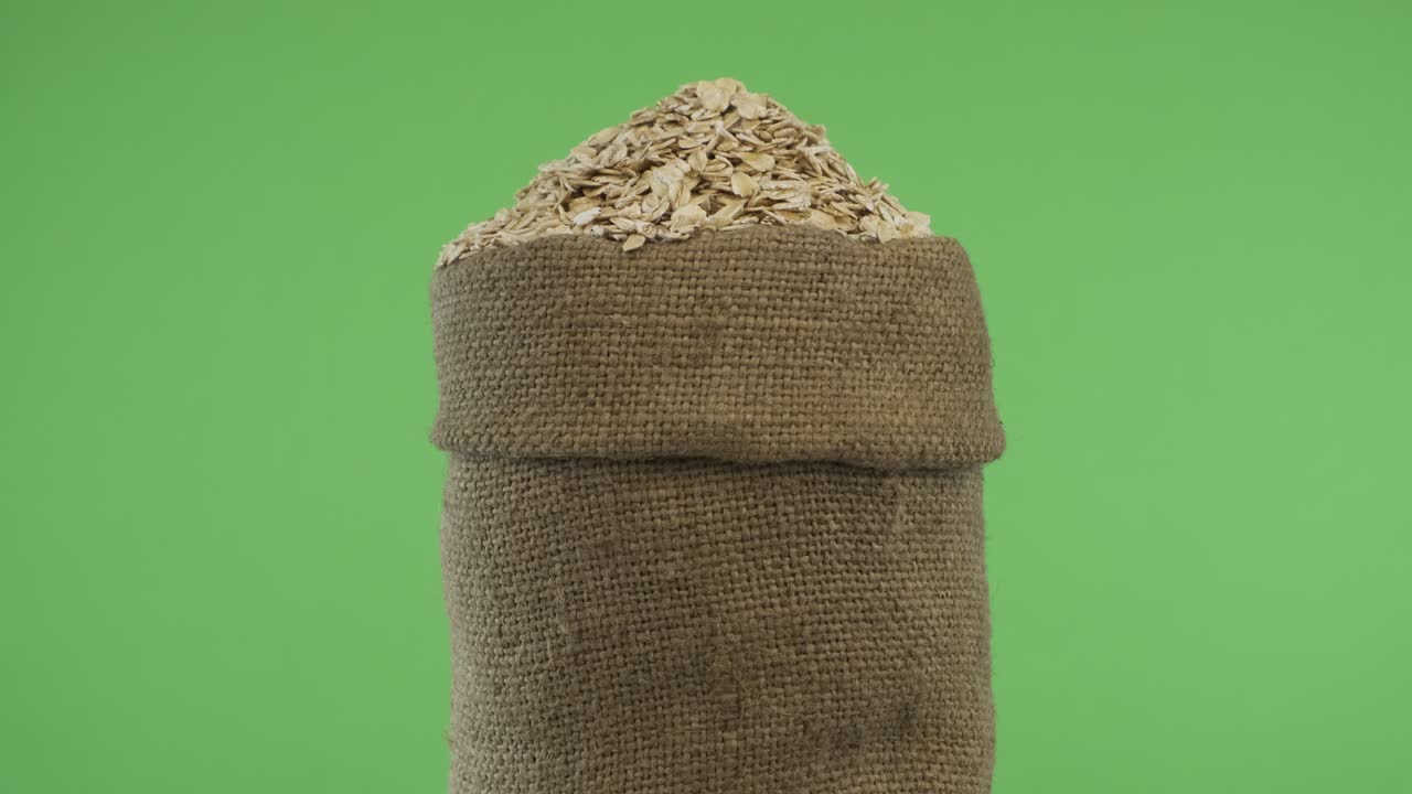 Rotating a full bag of oat flakes. Close-up.
