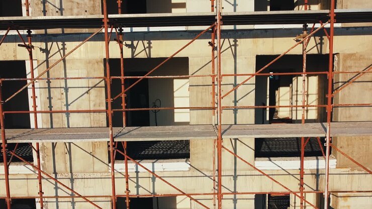 Construction works of a building with scaffolding on the facade. View from the drone. Bucharest, Romania