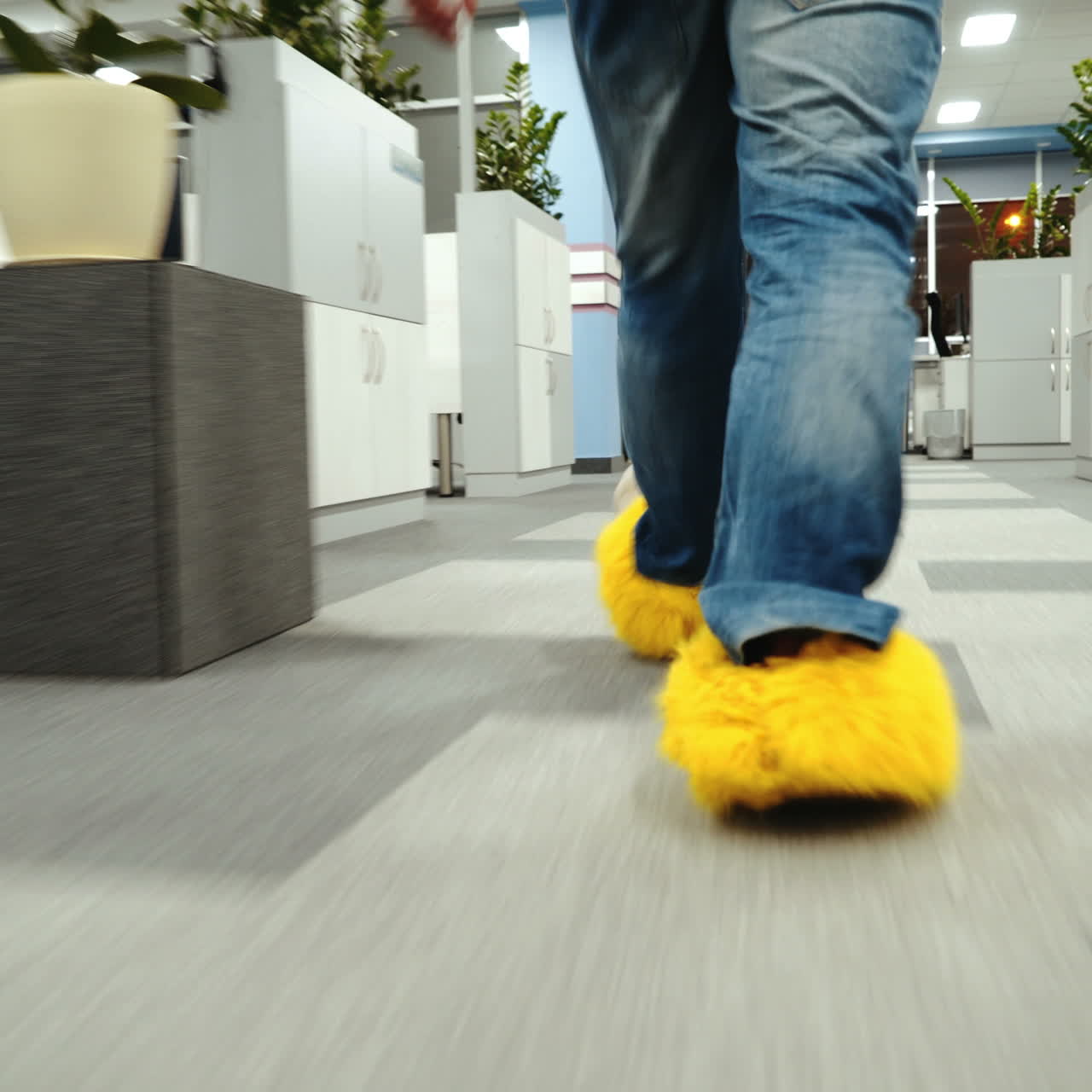 Office worker is running around in funny shoes. Male legs close-up walking around the office.