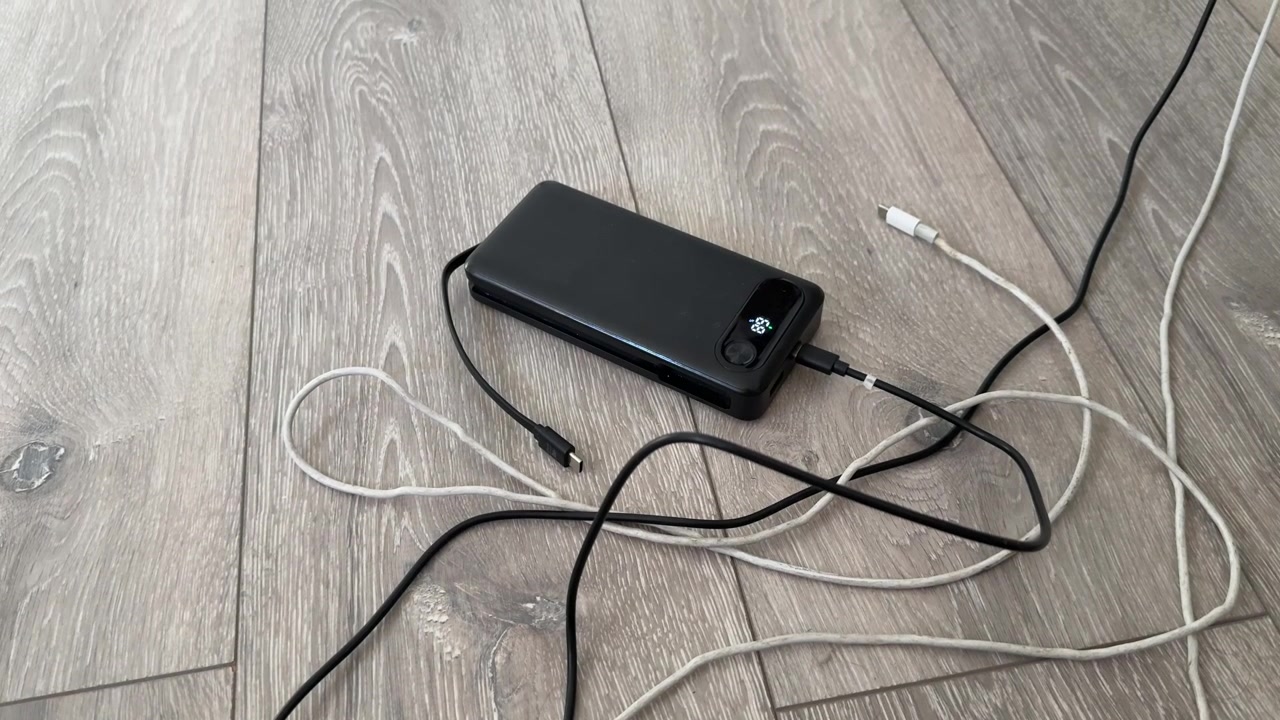 Power bank portatile con cavi di ricarica USB e accessori elettronici da viaggio sul letto