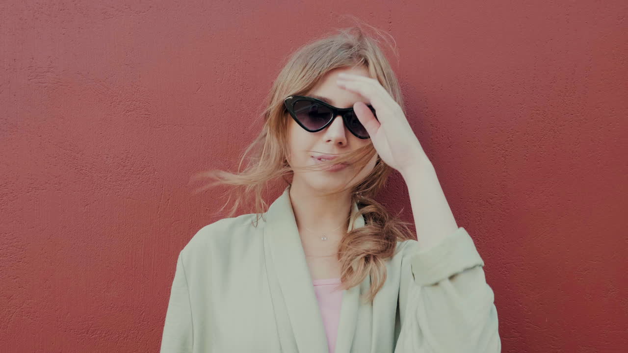 стильная женщина перед красной стеной