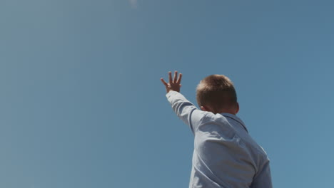 Child-waving-hand-to-the-plane-overhead