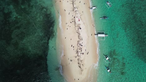 top view shot of bare island with boats docked and people enjoying the beach