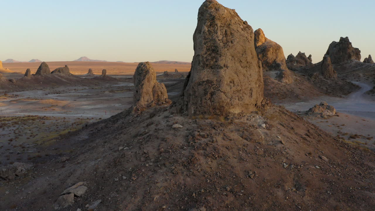 Ørkenlandskab opbrudt af enorme tufaspire i Trona Pinnacles, Californien.