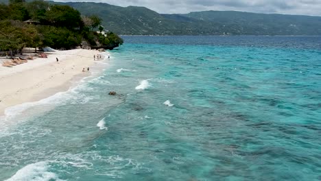 drone footage of crystal clear blue water and waves on the shore of beach in cebu philippines-13