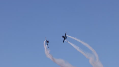 aviones realizando acrobacias con rastros de humo en el cielo