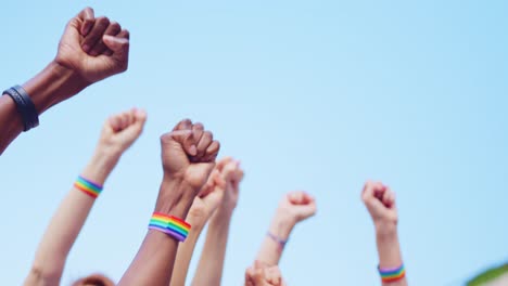 raised fists with rainbow bracelets symbolizing lgbtq+ protest and unity