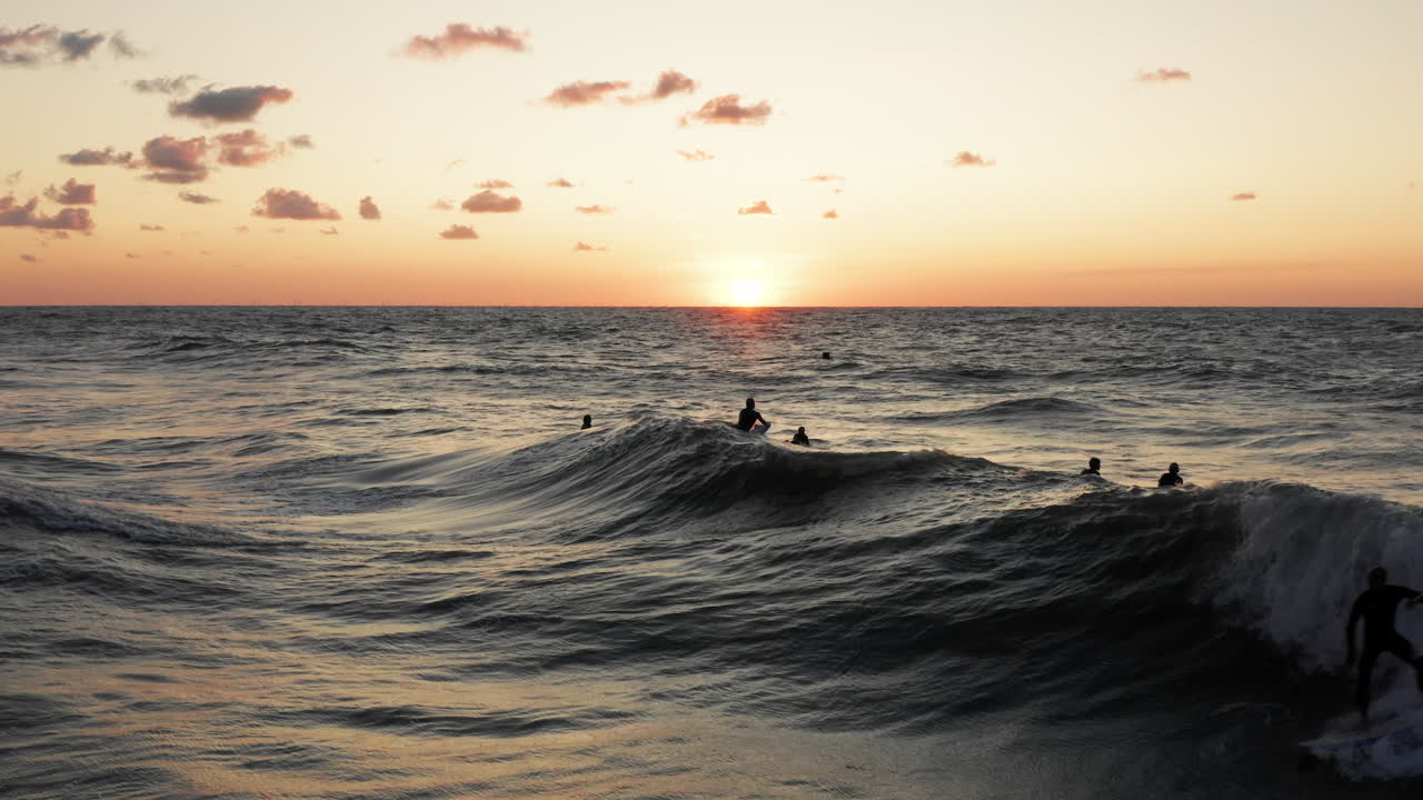 surfistas frente a la ciudad turística domburg en los países bajos durante la puesta de sol