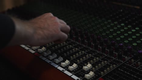 adjusting dials on a sound mixing board