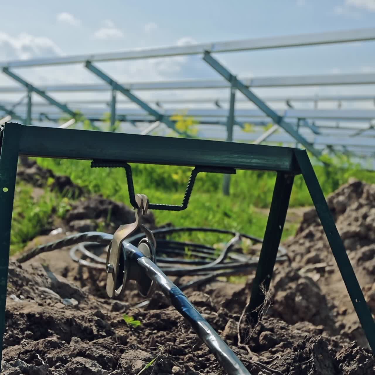 Construction of the solar farm in summer time. Metal equipment on the ground during the building of a new power station. Close-up.