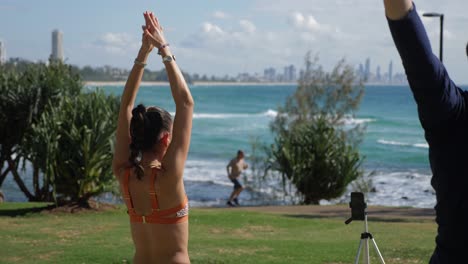 Yoga-Instructor-Stretching-And-Exercising-At-The-Park---Yoga-At-Beach---Burleigh-Heads-Beach-In-Summer---Gold-Coast,-Queensland,-Australia