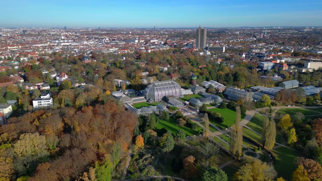 Berlin botanical garden tropical greenhouse glasshouses surrounded by autumn trees and city landscape. speed ramp hyper motion time lapse Fantastic aerial view flight panorama orbit drone