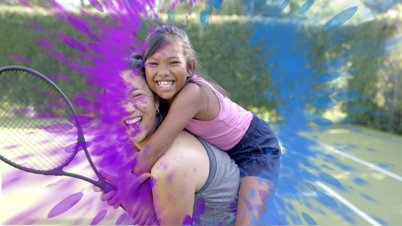 Woman carrying child holding racket on sports court smiling, making paint-splash grow showing hedge