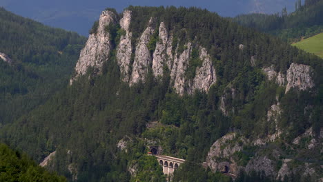 slow tilt up over rocky cliffs with train tracks in stunning nature landscape