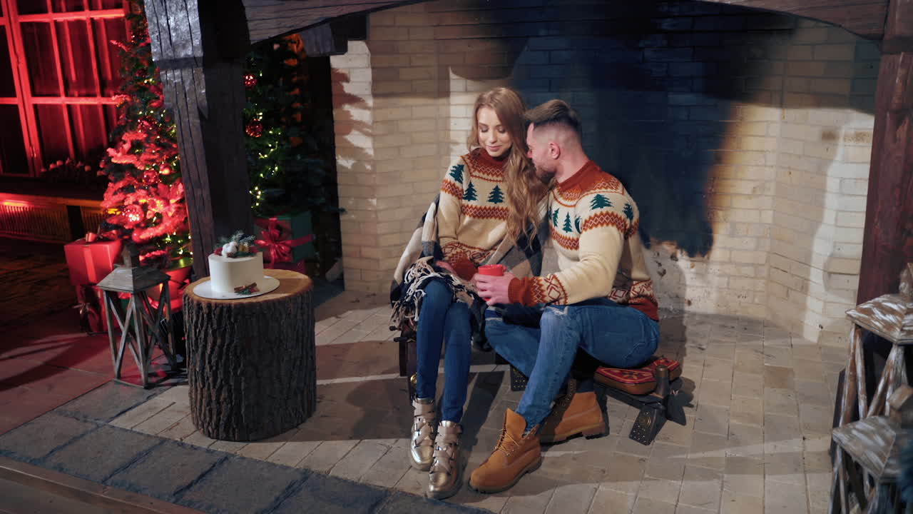 Couple in love in cozy Christmas house. Young people enjoying time together during winter holidays. Romantic evening indoors.