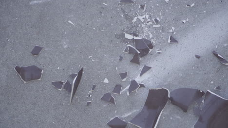 top down slow motion of broken brown ceramic pot smashing on concrete