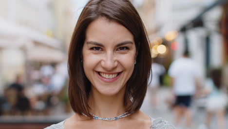 feliz mujer joven sonriendo mirando lejos soñando descansando buenas noticias sentirse satisfecho en la calle de la ciudad