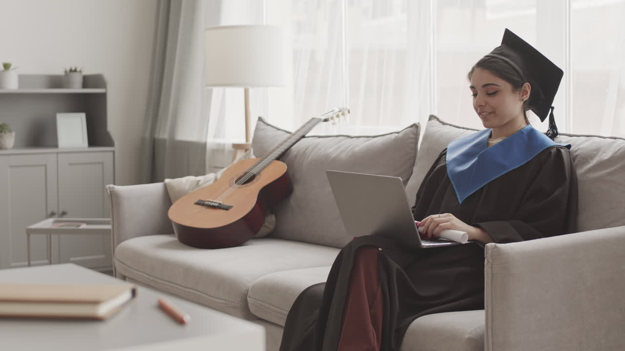 Female Graduate Sitting on Sofa and Having Video Call