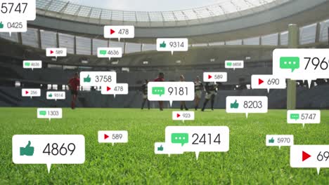 Animation-Von-Social-Media-Symbolen,-Die-Gegen-Ein-Team-Verschiedener-Rugbyspieler-Schweben,-Die-In-Einem-Stadion-Spielen