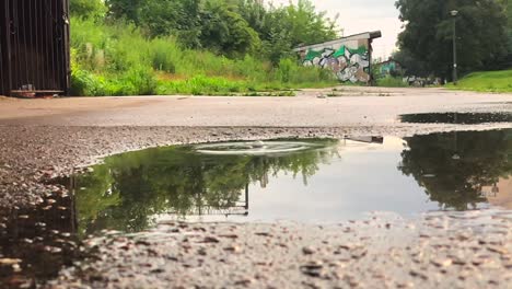 Blick-Auf-Wassertropfen,-Die-Nach-Einem-Regen-Auf-Die-Straßenoberfläche-Fallen