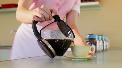 camarera vertiendo café negro en una taza en el restaurante 4k