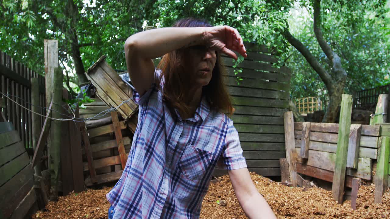 정원에서 정원 포크를 사용하는 성숙한 여성 4k