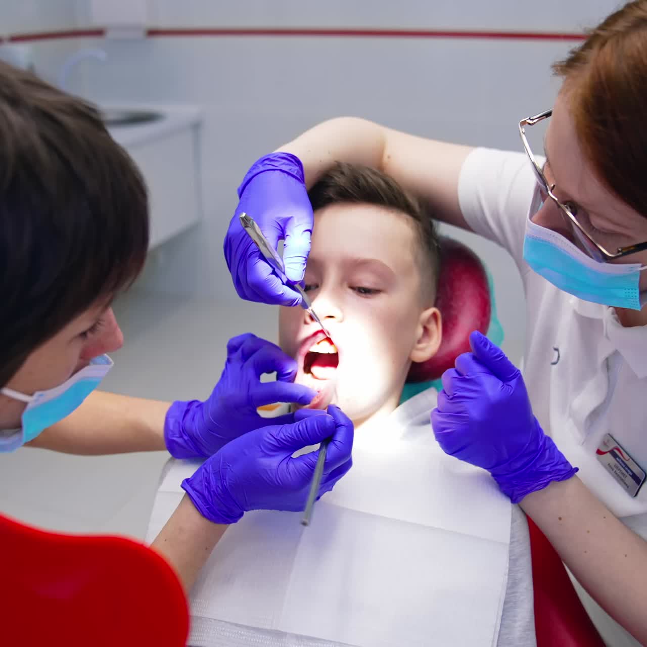 Young boy in dental surgery. Portrait of professional medical team and young patient during dental checkup