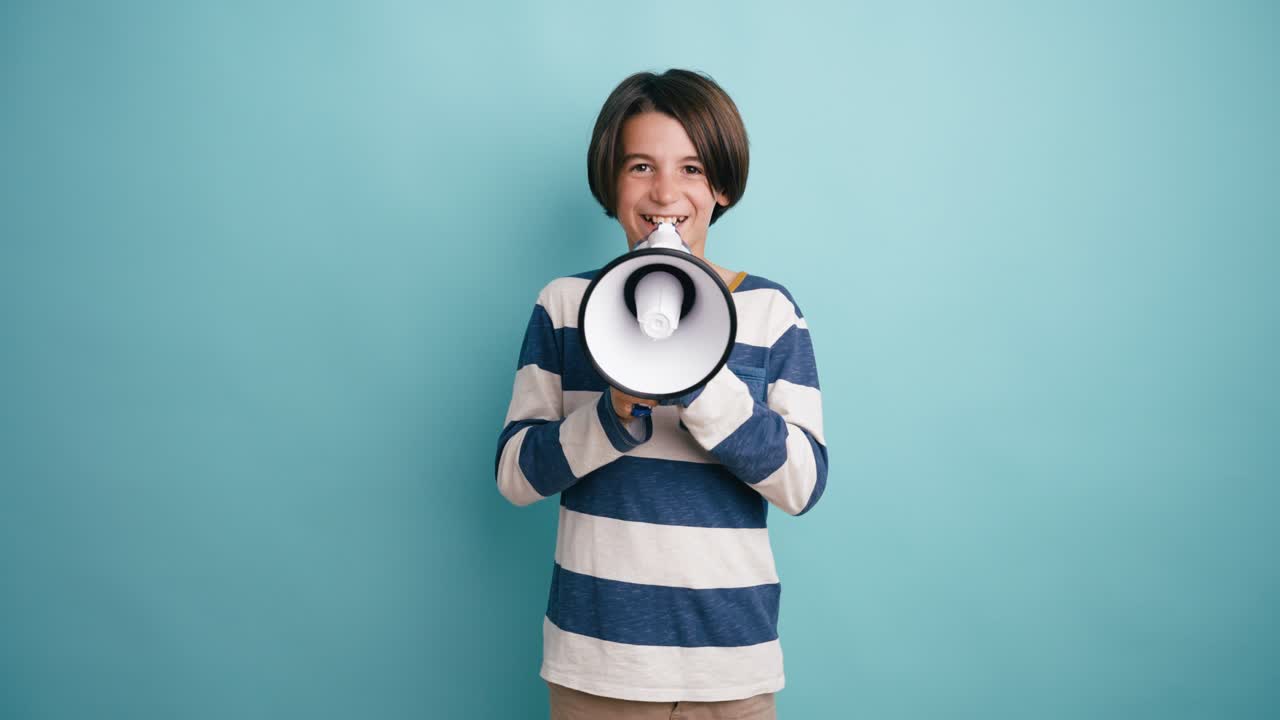 Happy Young Boy Shouting into a Megaphone in a Studio