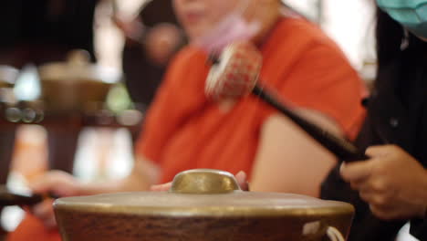 mallet being used to hit traditional indonesian bonang instrument, filmed as close up