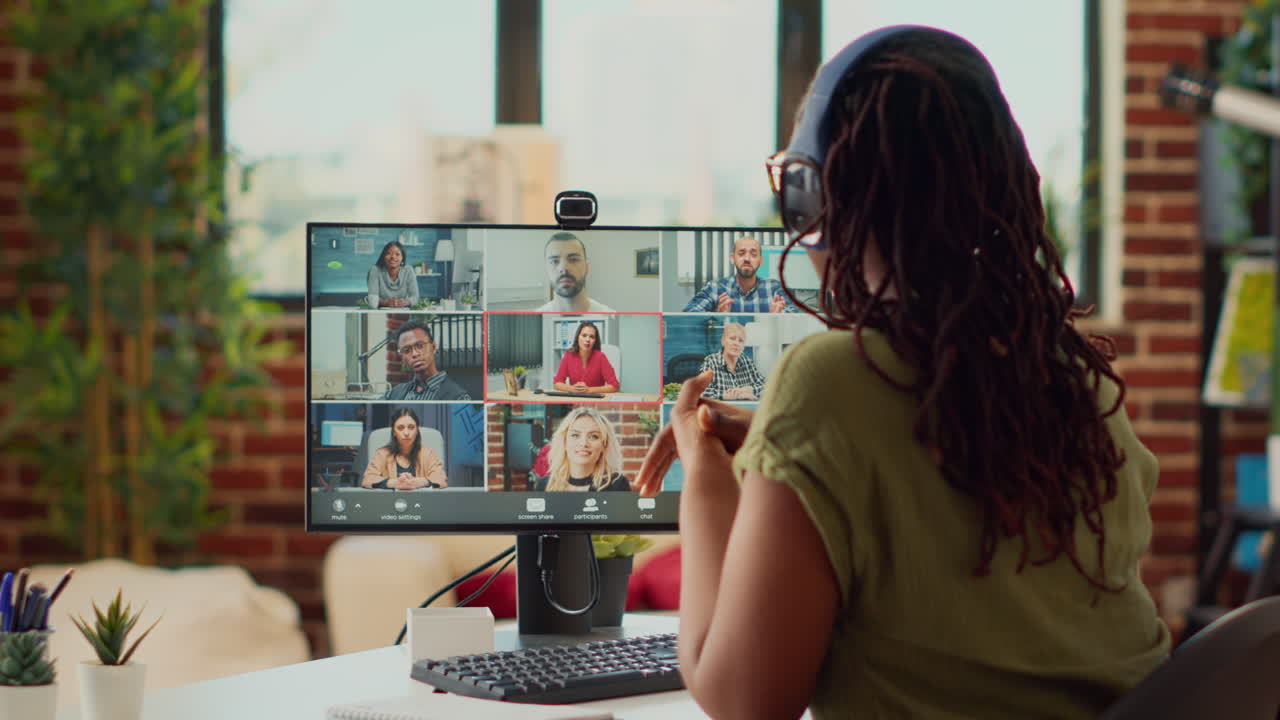 Female employee attending remote videocall meeting on webcam