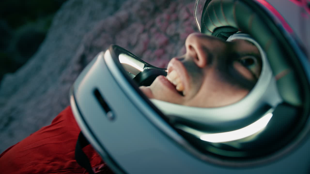 우주비행사는 새 행성의 건조한 지형에 누워있는 밤에 별을 관찰합니다.