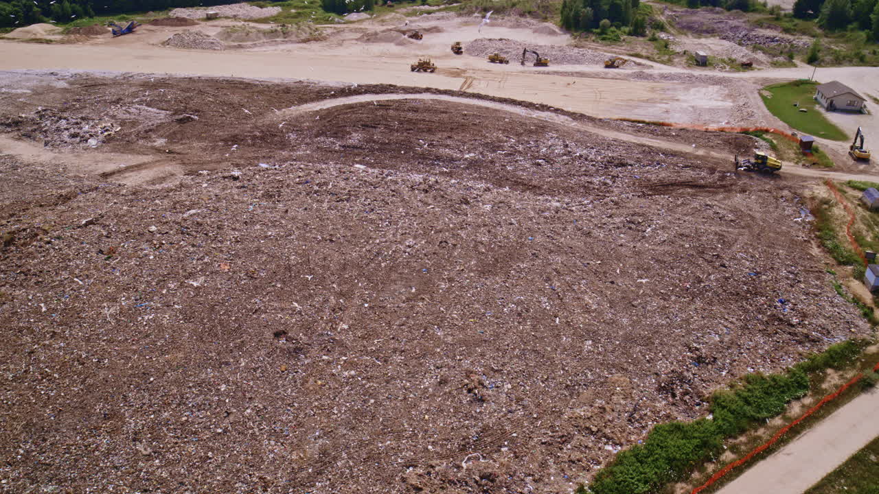 Drone shot flying around dump with huge amounts of birds flying around