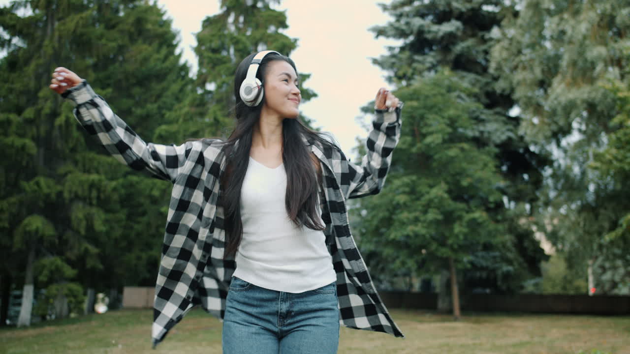 Woman Dancing in a Park with Headphones