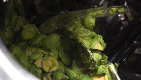 avocados  being processed into guacamole