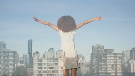 animation of cityscape over african american woman with arms outstretched