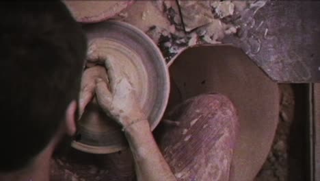 the potter makes a jug of clay. vintage effect. a man makes a vase on a potter's wheel