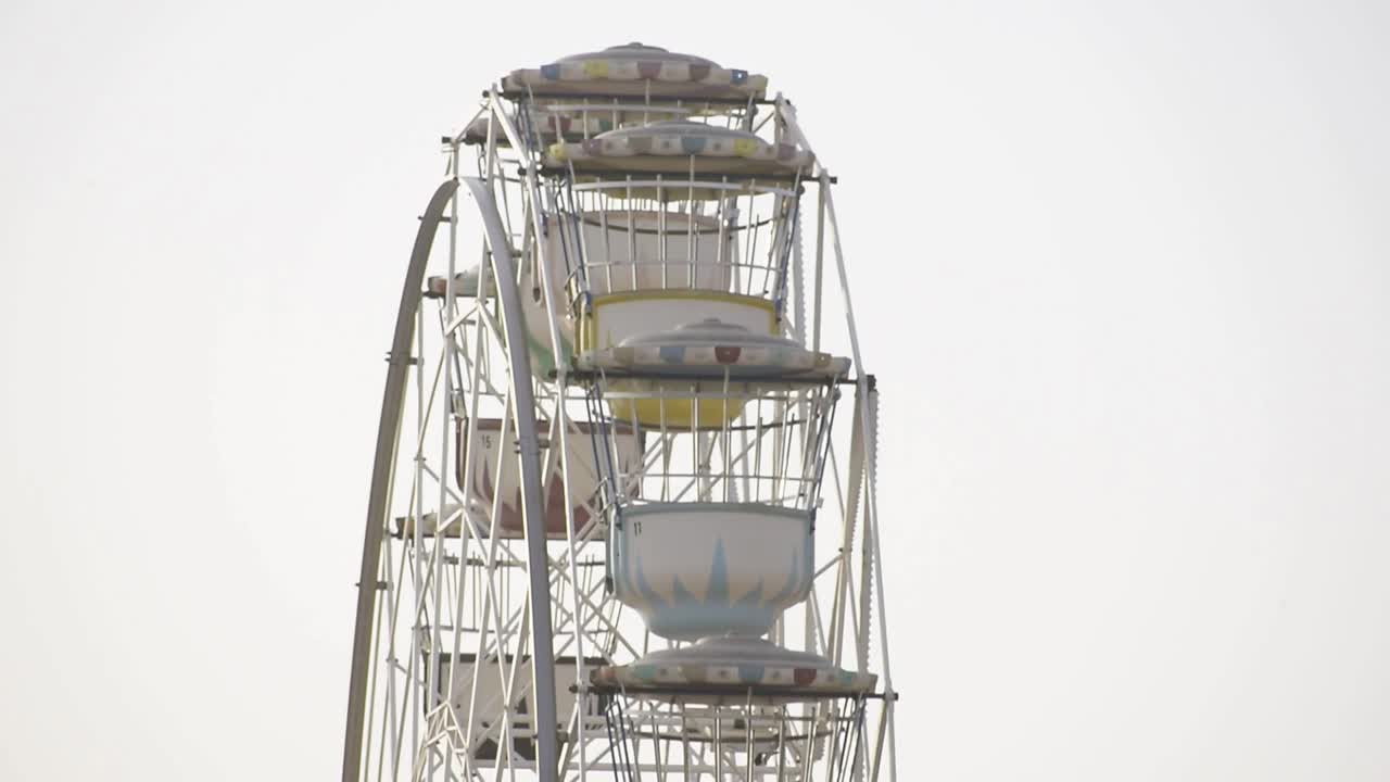 멋진 페리스 이 안개 속에서 구름이 가득한 하늘을 향해 회전하고 있습니다.