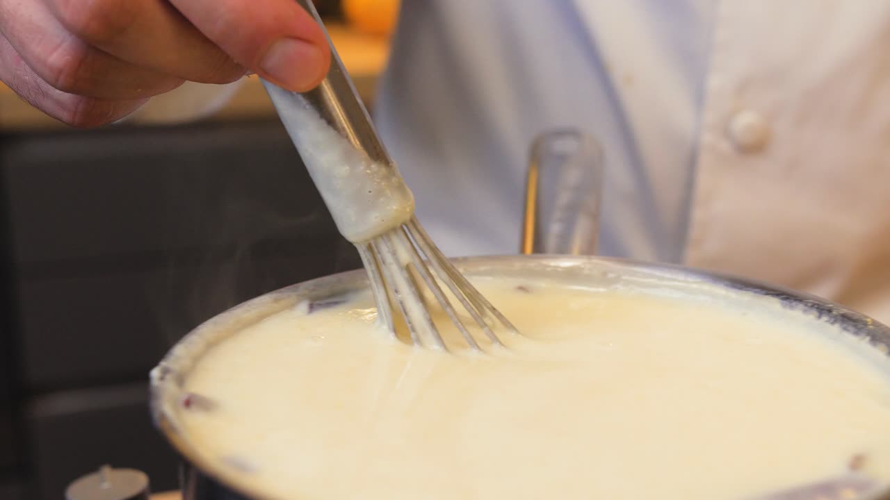 le cuisinier mélange le pudding dans une casserole