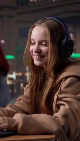 vertical video girl studying in the library to obtain her diploma with focus music on headset