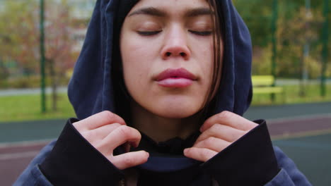 woman putting hoodie on