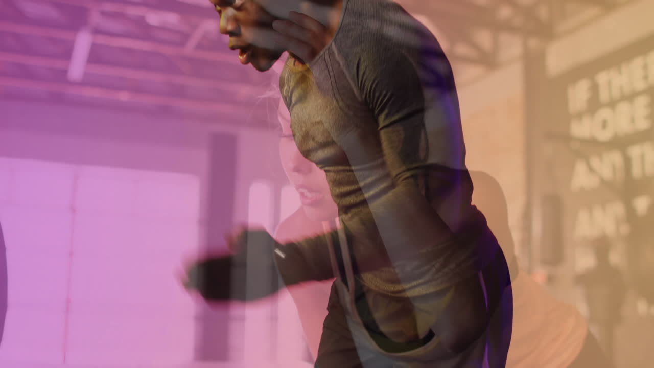 In gym, man exercising intensely with animation overlay of woman working out