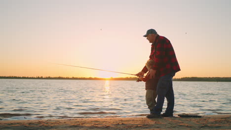 Un-Niño-Feliz-Con-Su-Abuelo-En-Una-Familia-De-Pescadores-Pasa-El-Fin-De-Semana-En-La-Orilla-Del-Río-O-Lago