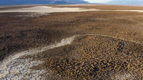 aerial over devils golf course at death valley national park showing rugged terrain covered with large salt pans