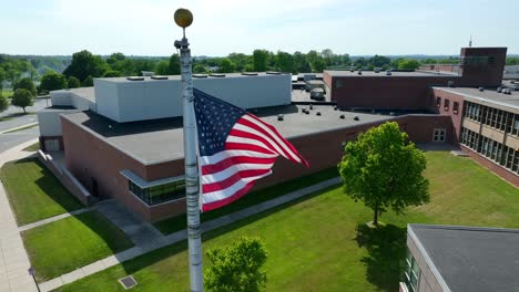 american flag waving outside of school in usa