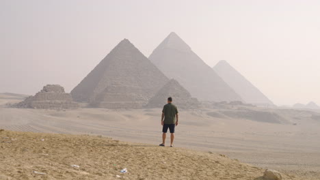 A Man Near Giza Pyramid Complex During Sunrise In Al Haram, Giza, Egypt. Static Shot