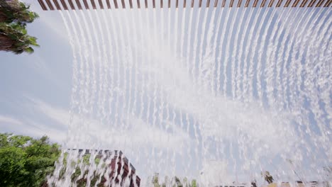 water curtain fountain with palm trees against blue sky