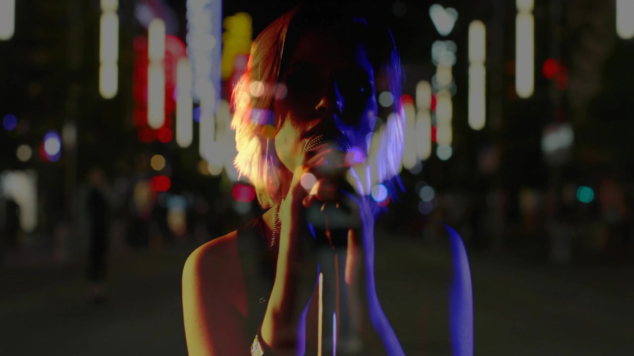Female musician reacting to beat, reaching mic while dual neon lights overlaying performer to sing