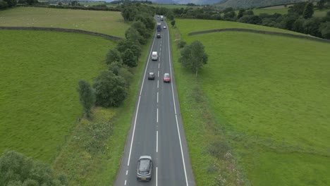 Busy-countryside-highway-A66-with-trucks-and-cars,-slow-rise-up-with-mountainous-horizon-reveal
