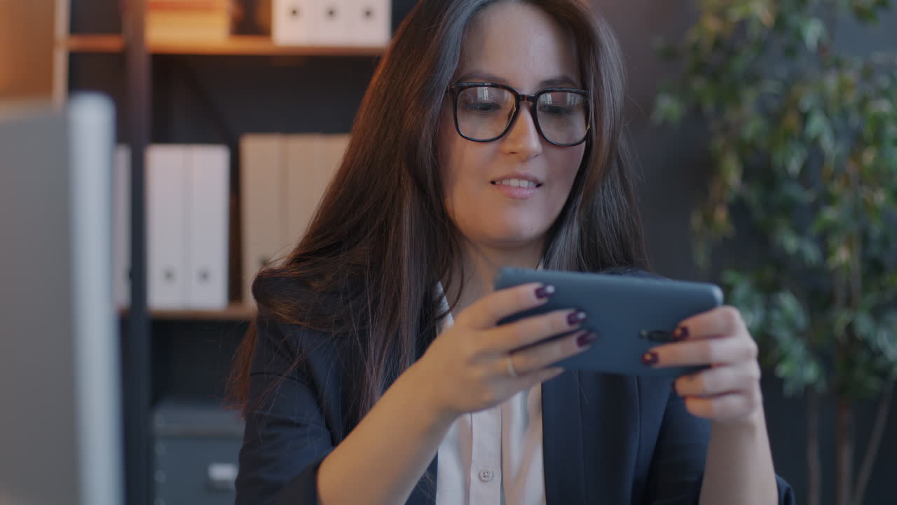 Businesswoman playing games on her phone in the office